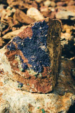 Yer yakın çekimham cevheri. Güneş ışığında çok renkli kaba taş. Kaba taş yığını ile dokulu canlı jeolojik arka plan. Kopyalama alanı ile doğal doku. İnanılmaz bir mineral. Kaya parçası.