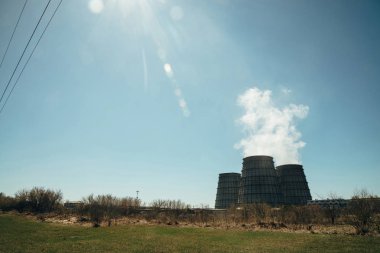 Chpp'nin üç büyük kulesi yakın çekim. Mavi gökyüzünde Chp'nin geniş borusundan beyaz buhar. Kopyalama alanı ile Tpp endüstriyel arka plan görüntüsü. Termik santralin büyük borular elektrik enerjisi için buhar üretmek.