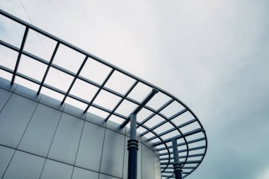 Gökyüzüne karşı modern bir cam binanın yuvarlak bir cephe.