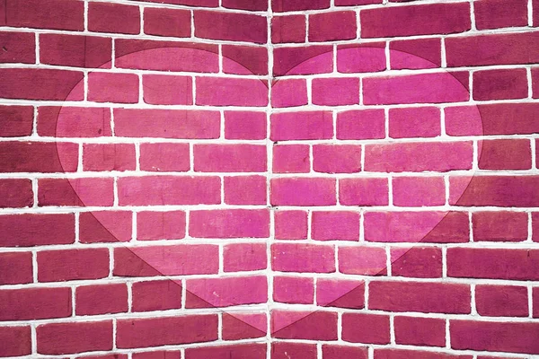 Symmetric drawn heart on pink brick wall close-up. Background with painted heart. Interior with love symbol decor. Valentine day image on wall. Brickwork with exterior picture. Angle of brick wall.