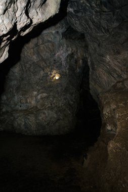Güzel bir mağara. Karanlık zindandan manzara. Mağaranın dokulu duvarları. Yeraltı tünelinin arka plan görüntüsü. Mağaranın içinde nem var. Geziler için mağara içinde Aydınlatma.
