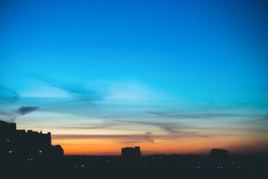 Harika varirenkli canlı şafak ile Cityscape. Şehir binalarının koyu siluetleri üzerinde mor ve mor bulutlar ile Inanılmaz dramatik mavi gökyüzü. Turuncu gündoğumu atmosferik arka plan. Kopyalama alanı.