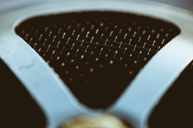 Parlak örgü ile otomatik parçası. Izgara yakın çekimin metalik dokusu. Altın refleksile ızgara üçgen şekli.