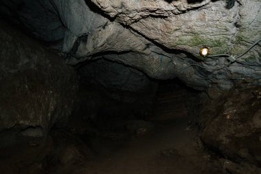 Güzel bir mağara. Karanlık zindandan manzara. Mağaranın dokulu duvarları. Yeraltı tünelinin arka plan görüntüsü. Mağaranın içinde nem var. Geziler için mağara içinde Aydınlatma.