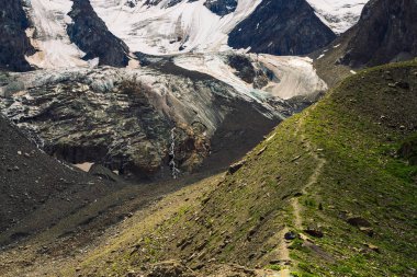 Dev buzulun etekleri. İnanılmaz büyük dağ kayalık doğal duvar. Büyük ağlayan göz şeklinde kar ve buz ile Rocky kabartma. Dağlık patikada. Görkemli doğanın harika fantastik sanat
