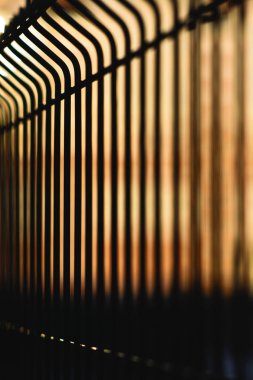 Turuncu bir gökyüzünün arka planına karşı metal dövme çit. Günbatımı. Minimalizm.