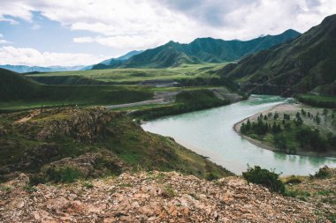 Dağlık havalarda dağlık nehir. Bulutlu gökyüzü altında hızlı su akıntısı üzerinde Kayalık uçurum. Dev dağlar. Yukarıdan inanılmaz atmosferik manzara.