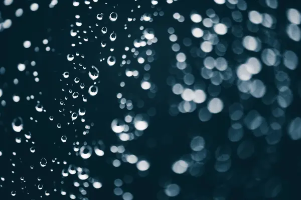 雨の滴と汚れた窓ガラス ボケの雨滴を持つ大気の青い背景 液滴と汚れがクローズアップ コピースペースを持つマクロ内の詳細な透明テクスチャ — ストック写真