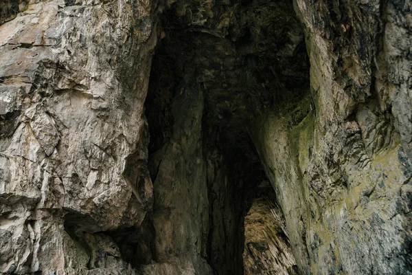 美しい洞窟だ暗いダンジョンの中からの眺め 洞窟のテクスチャードの壁 地下トンネルの背景画像 洞窟内の湿気 トンネルの終点の光 — ストック写真