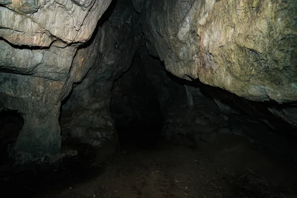 Güzel bir mağara. Karanlık zindandan manzara. Mağaranın dokulu duvarları. Yeraltı tünelinin arka plan görüntüsü. Mağaranın içinde nem var. Tünelin sonundaki ışık.