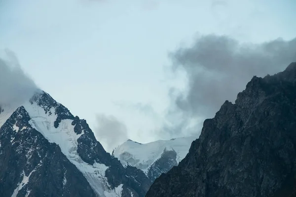 巨大な氷河の前に低い雲 曇り空の下に巨大な雪の岩山 早朝の山々は濃霧 不可解な霧冷たい岩暗い大気の風景 静かな雰囲気 — ストック写真