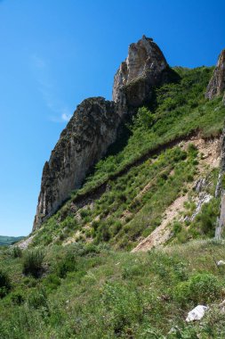 Kayalık dağlar yeşilliklerle kaplı.