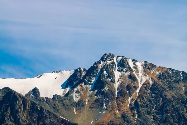 雪山山顶在蔚蓝清澈的天空 在阳光明媚的日子里 在云层下的岩石山脊 雄伟的自然景观的大气简约景观 — 图库照片