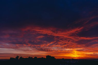 Ateşli kırmızı kanlı vampir şafağı. İnanılmaz sıcak dramatik yangın mavi karanlık bulutlu gökyüzü. Turuncu güneş ışığı. Bulutlu havalarda gün doğumunun atmosferik arka planı. Sert bulutluluk. Fırtına bulutları uyarısı. Kopyalama alanı