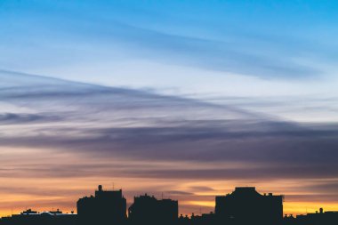 Harika varirenkli canlı şafak ile Cityscape. Şehir binalarının koyu siluetleri üzerinde mor ve mor bulutlar ile Inanılmaz dramatik mavi gökyüzü. Turuncu gündoğumu atmosferik arka plan. Kopyalama alanı.