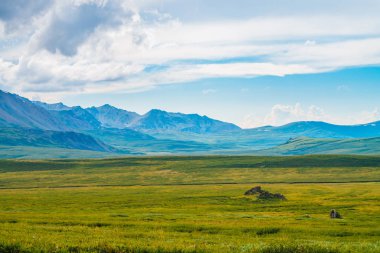 Bulutlu gökyüzü altında dev dağların muhteşem görünümü. Bulutlu havalarda büyük bir dağ sırası. Harika vahşi manzara. Görkemli doğanın atmosferik yayla manzarası. Doğal dağ manzarası.