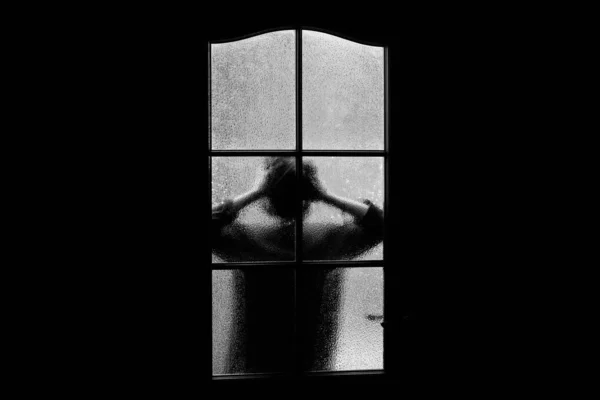 ガラスの後ろの女の子の暗いシルエット ハロウィーンのドアの後ろの部屋に 一人で閉じ込められて グレースケールでエイリアン モンスターや幽霊と子供の悪夢 モノクロで家の中の悪 お化け屋敷の中 — ストック写真