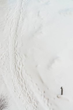 Beyaz karda ayakkabı izleri. Kar akıntısı üzerinde botların izini. Karlı patikanın dokulu kış arka planı. Kar kopya alanı ile mahzen kaplı. Soyut minimalist karlı hava dokusu. Karda boru.
