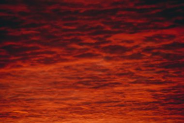 Ateşli kırmızı kanlı vampir şafağı. İnanılmaz sıcak dramatik ateş bulutlu gökyüzü. Canlı turuncu güneş ışığı. Bulutlu havalarda gün doğumunun atmosferik arka planı. Sert bulutluluk. Fırtına bulutları uyarısı. Kopyalama alanı.