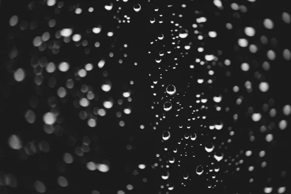 雨の滴と汚れた窓ガラス ボケの雨滴を持つ大気モノクロ暗い背景 液滴と汚れがクローズアップ マクロで詳細な透明なテクスチャ スペースをコピーします — ストック写真