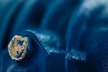 Altın cıvata ile parçası mavi metal pürüzlü yüzey. Mavi otomobil parçası boyalı. Otomotiv grunge arka plan görüntüsü.