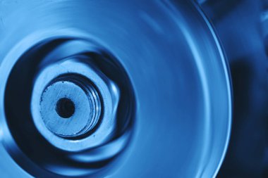 Dönen mekanizmayakın çekim in bir parçası. Kobalt tonlarında acımasız otomatik parça. Metal cihazın tek renkli mavi arka planı.