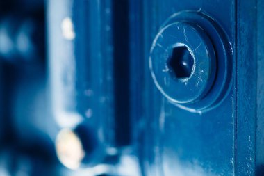 Altın cıvata ile parçası mavi metal pürüzlü yüzey. Mavi otomobil parçası boyalı. Otomotiv grunge arka plan görüntüsü.