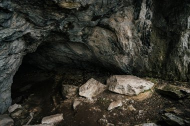 Güzel bir mağara. Karanlık zindandan manzara. Mağaranın dokulu duvarları. Yeraltı tünelinin arka plan görüntüsü. Mağaranın içinde nem var. Tünelin sonundaki ışık.