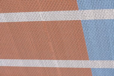 Beyaz çizgilerile mavi ve turuncu tuğla duvar. Duvar modern bina yakın çekim arka plan.