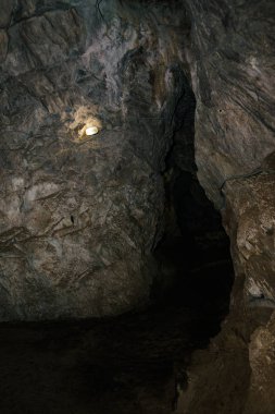 Güzel bir mağara. Karanlık zindandan manzara. Mağaranın dokulu duvarları. Yeraltı tünelinin arka plan görüntüsü. Mağaranın içinde nem var. Geziler için mağara içinde Aydınlatma.