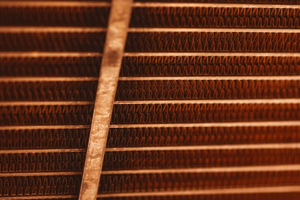 Lattice texture of old rusty radiator with copy space. Background of automotive radiator close-up. Abstract artwork with auto part in macro.