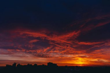 Ateşli kırmızı kanlı vampir şafağı. İnanılmaz sıcak dramatik yangın mavi karanlık bulutlu gökyüzü. Turuncu güneş ışığı. Bulutlu havalarda gün doğumunun atmosferik arka planı. Sert bulutluluk. Fırtına bulutları uyarısı. Kopyalama alanı