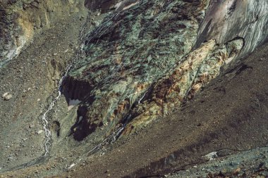 Dev buzulun etekleri. Kar ve buz ile inanılmaz kayalık kabartma. Küçük şelaleler ile Harika büyük dağ kayalık doğal duvar. Buzuldan gelen su. Görkemli yayla doğanın Fantastik sanat.