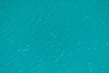 Dağ gölünün masmavi yüzeyinin parlak dokusu. Güneşli bir günde berrak suda yansıması ile Minimalist arka plan. Kopyalama alanı.