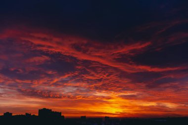 Ateşli kırmızı kanlı vampir şafağı. İnanılmaz sıcak dramatik yangın mavi karanlık bulutlu gökyüzü. Turuncu güneş ışığı. Bulutlu havalarda gün doğumunun atmosferik arka planı. Sert bulutluluk. Fırtına bulutları uyarısı. Kopyalama alanı