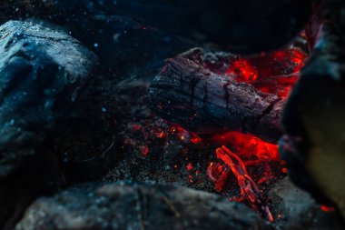 Yanan kütükler canlı ateşte yandı. Kamp ateşi turuncu alev ile atmosferik arka plan. Kopya alanı ile içeriden şenlik ateşi hayal edilemez ayrıntılı görüntü. Duman ve kül kasırgası yakın.