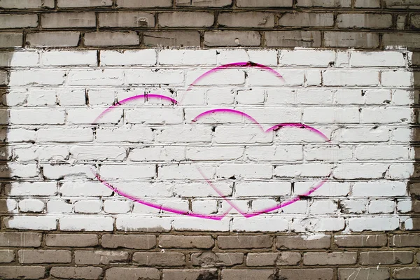 Two drawn hearts on brick wall with white paint close-up. Mock up. Urban background with two painted hearts. Imperfect exterior with love symbol graffiti. Valentine day image. Unideal brickwork.