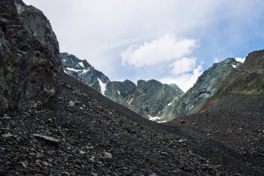 Dağ lık dağda kar. Mavi bulutlu gökyüzü altında atmosferik karlı sırt. Harika dev kayalar. Dağlarda yükseke tırmanın. Yaylaların görkemli doğasının inanılmaz minimalist manzarası.
