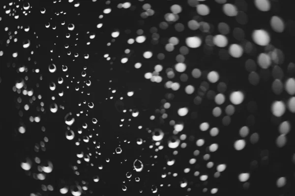 雨の滴と汚れた窓ガラス ボケの雨滴を持つ大気モノクロ暗い背景 液滴と汚れがクローズアップ マクロで詳細な透明なテクスチャ スペースをコピーします — ストック写真