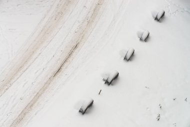 Karlı yol. Eski tekerleklerin eskrim. Lastiklerden çit. Dokulu kış arka planı. Soyut minimalist karlı hava dokusu. Kirli karda araba yolu. Yukarıdan görüntüleyin. Karda insan ve evcil hayvan izleri.