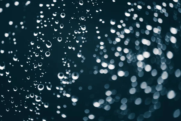 雨の滴と汚れた窓ガラス ボケの雨滴を持つ大気の青い背景 液滴と汚れがクローズアップ コピースペースを持つマクロ内の詳細な透明テクスチャ — ストック写真