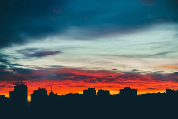 素晴らしいバリエーションの鮮やかな夜明けと都市景観 都市の建物の暗いシルエットの上に驚くほど劇的な多色の曇り空 曇りの天候の日の出の大気の背景 スペースのコピー — ストック写真