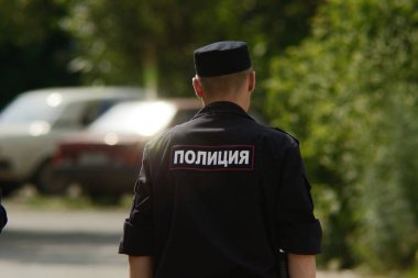 Russia, Barnaul city - July, 08, 2014: Russian policeman patrols street of provincial town clipart