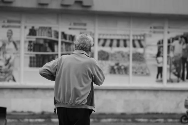 Russia, Barnaul - 31 July, 2014: Elderly gray-haired man looking at shop window
