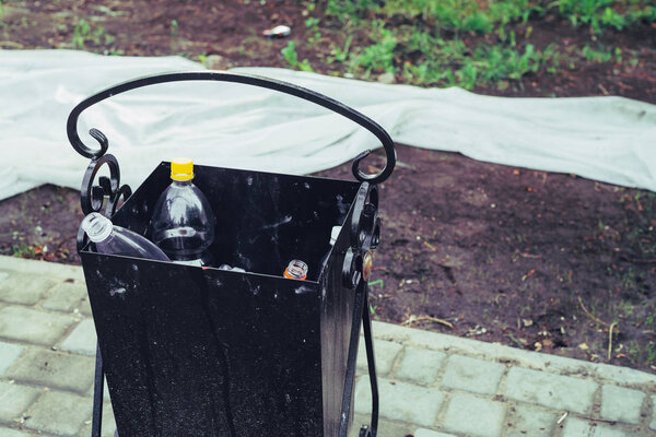 Toxic plastic in trash can in city, urban background
