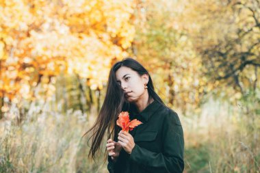 Canlı yeşilliklerle çevrili bir kadın portresi.