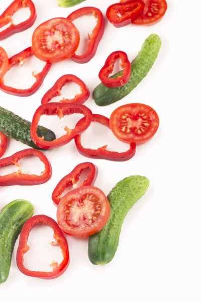 Los trozos del pepino el tomate y el pimiento sobre el fondo blanco —  Fotos de Stock