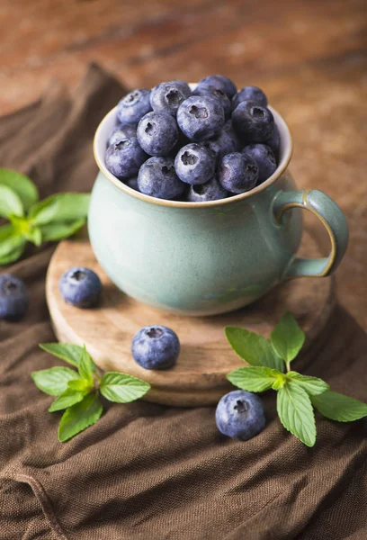 Blueberry in a cup on a wooden background — Stock Photo, Image