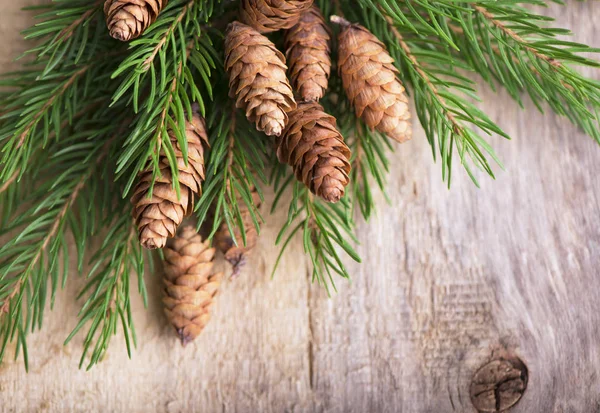 Kerstmis houten achtergrond met spar takken en kegels — Stockfoto