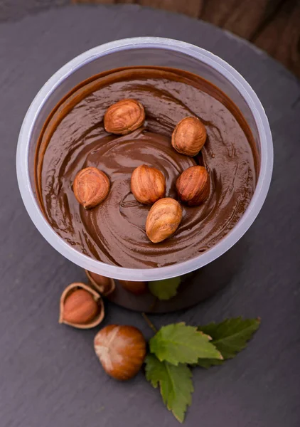 Pão com avelã de chocolate doce espalhado no fundo de madeira — Fotografia de Stock